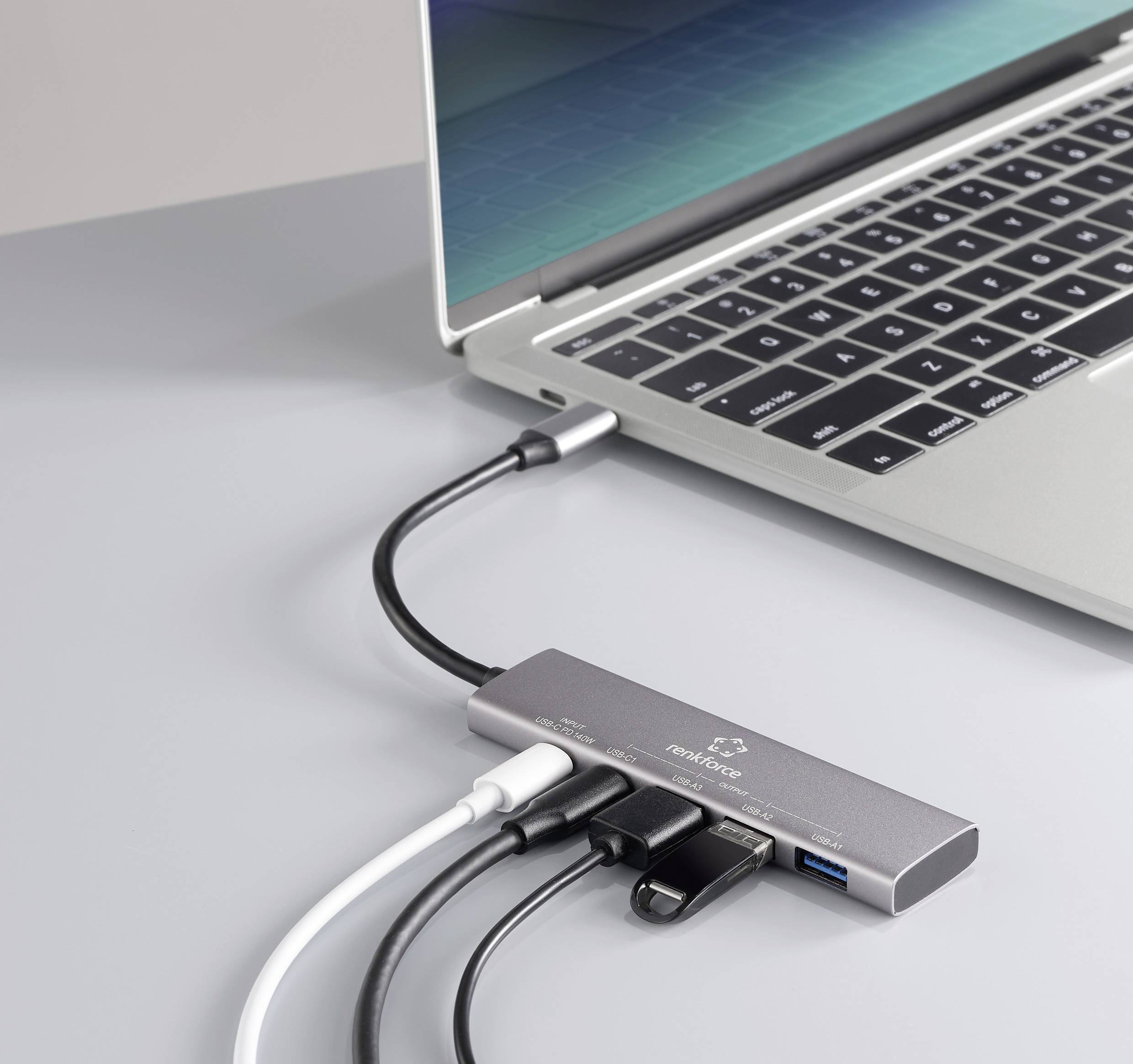 Een laptop is verbonden met een USB-C-hub die meerdere aansluitingen biedt, waaronder USB, HDMI en een kaartlezer.
