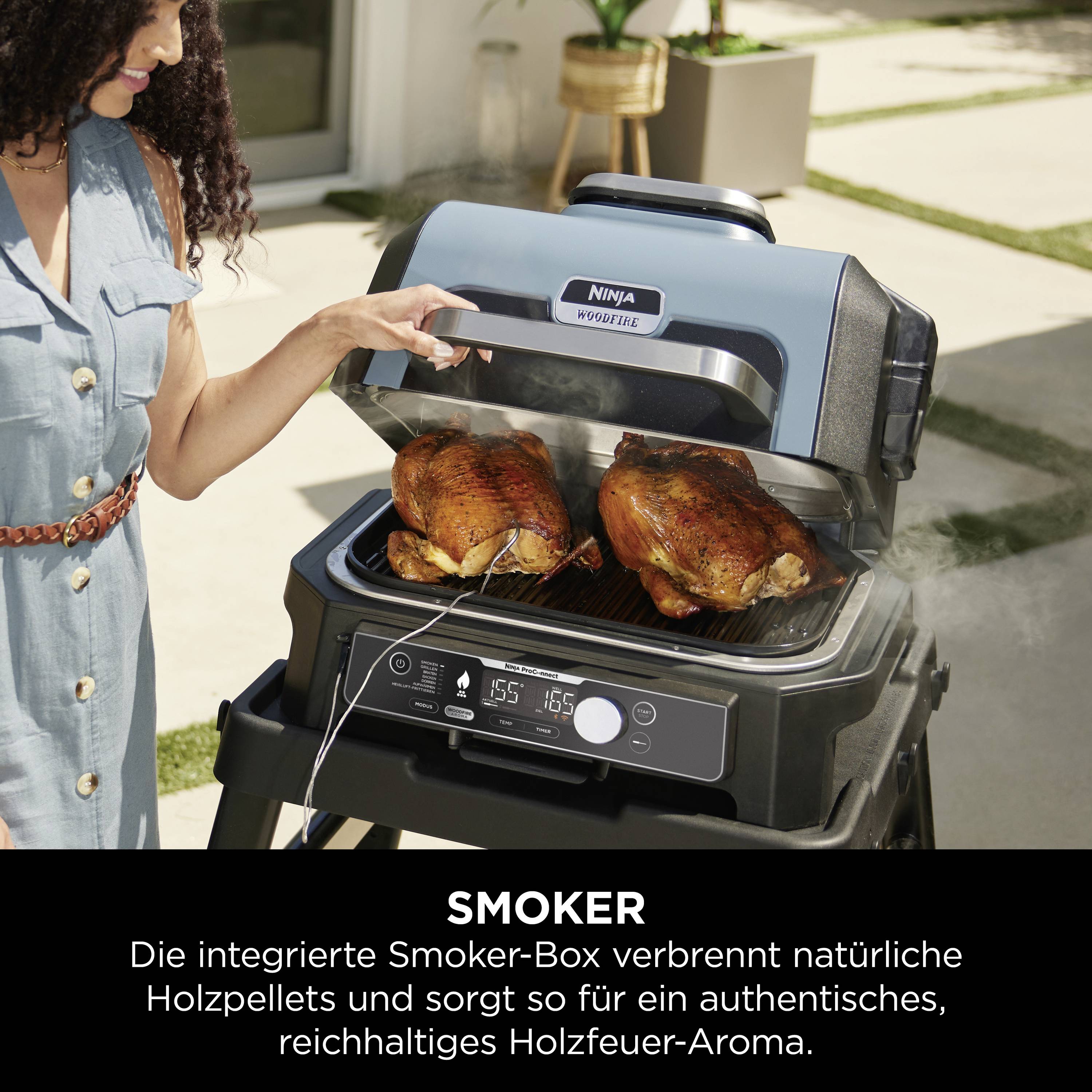 Een vrouw staat naast een smoker-grill met twee gegrilde kippen. De tekst legt de houtaroma-functie van de smoker uit.