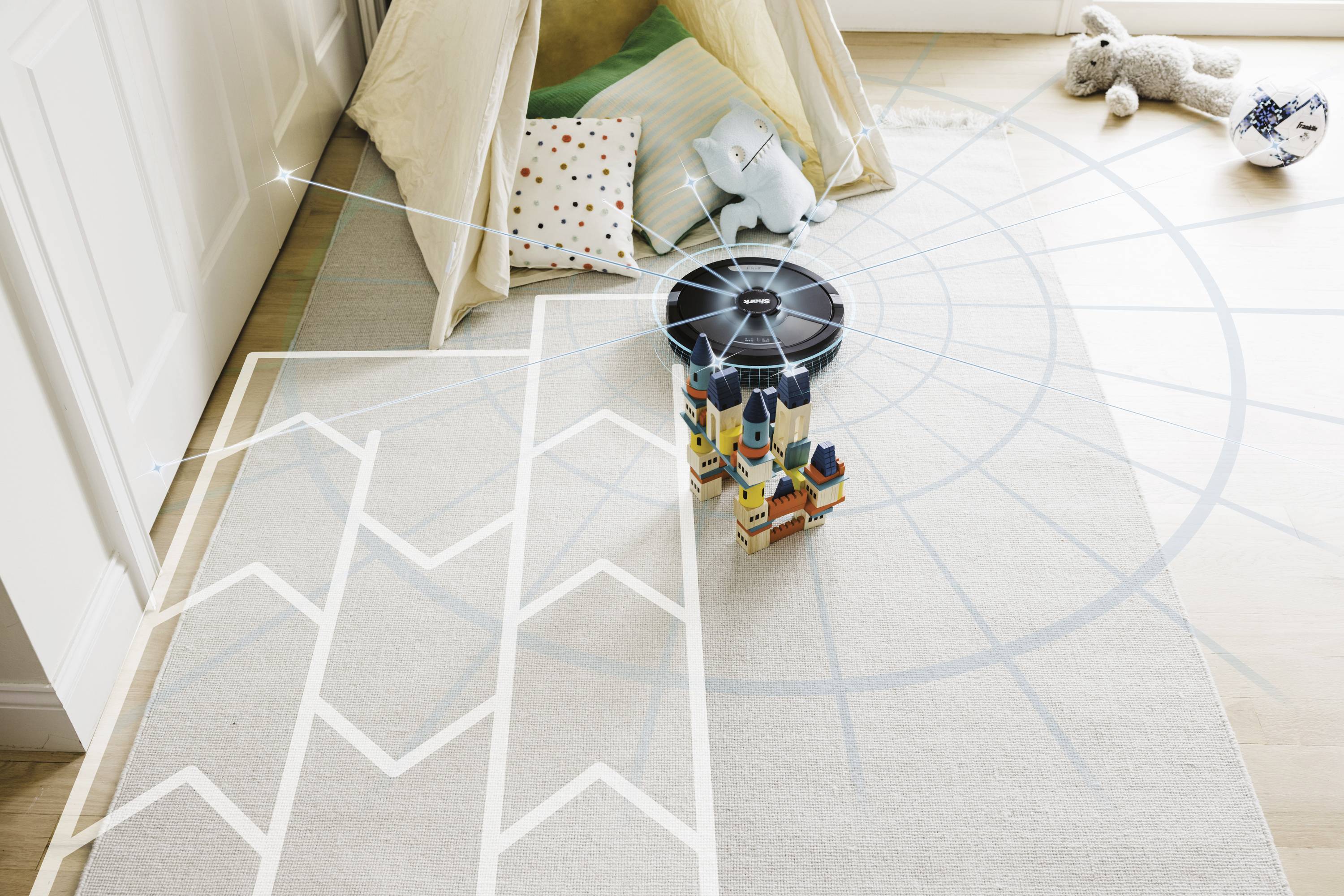 Een kinderkamer met een houten vloer, een tent met kussens, en speelgoed op de grond, waaronder een knuffel en blokken.