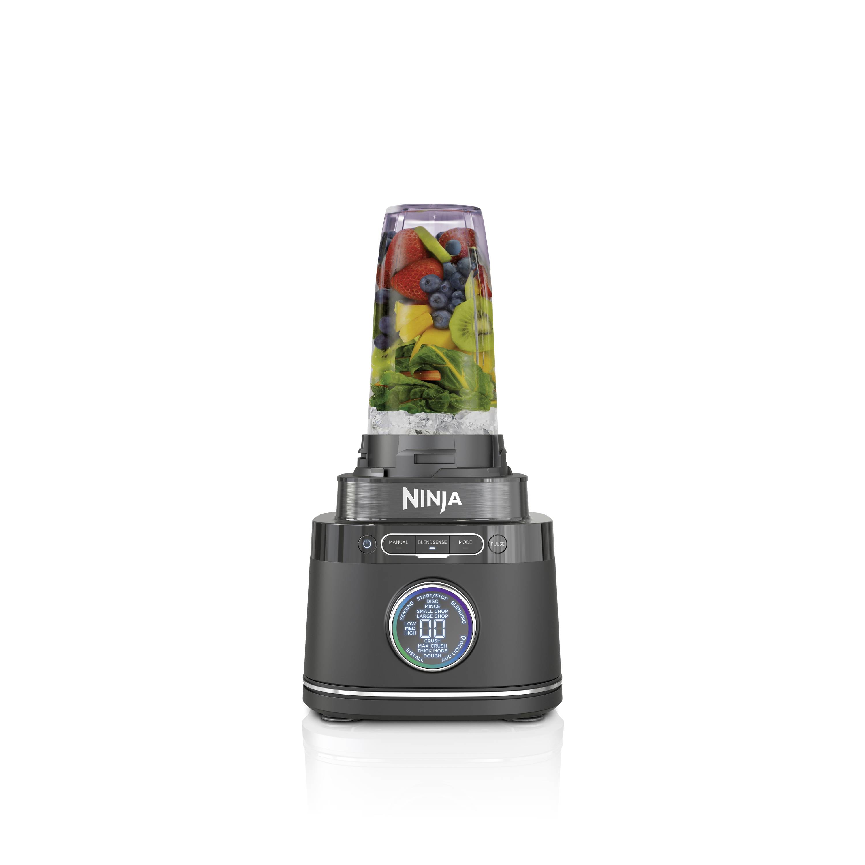 Zwarte blender met een transparante container, gevuld met fruit en groenten. Het apparaat vertoont het merk 'Ninja' en heeft een digitaal display.