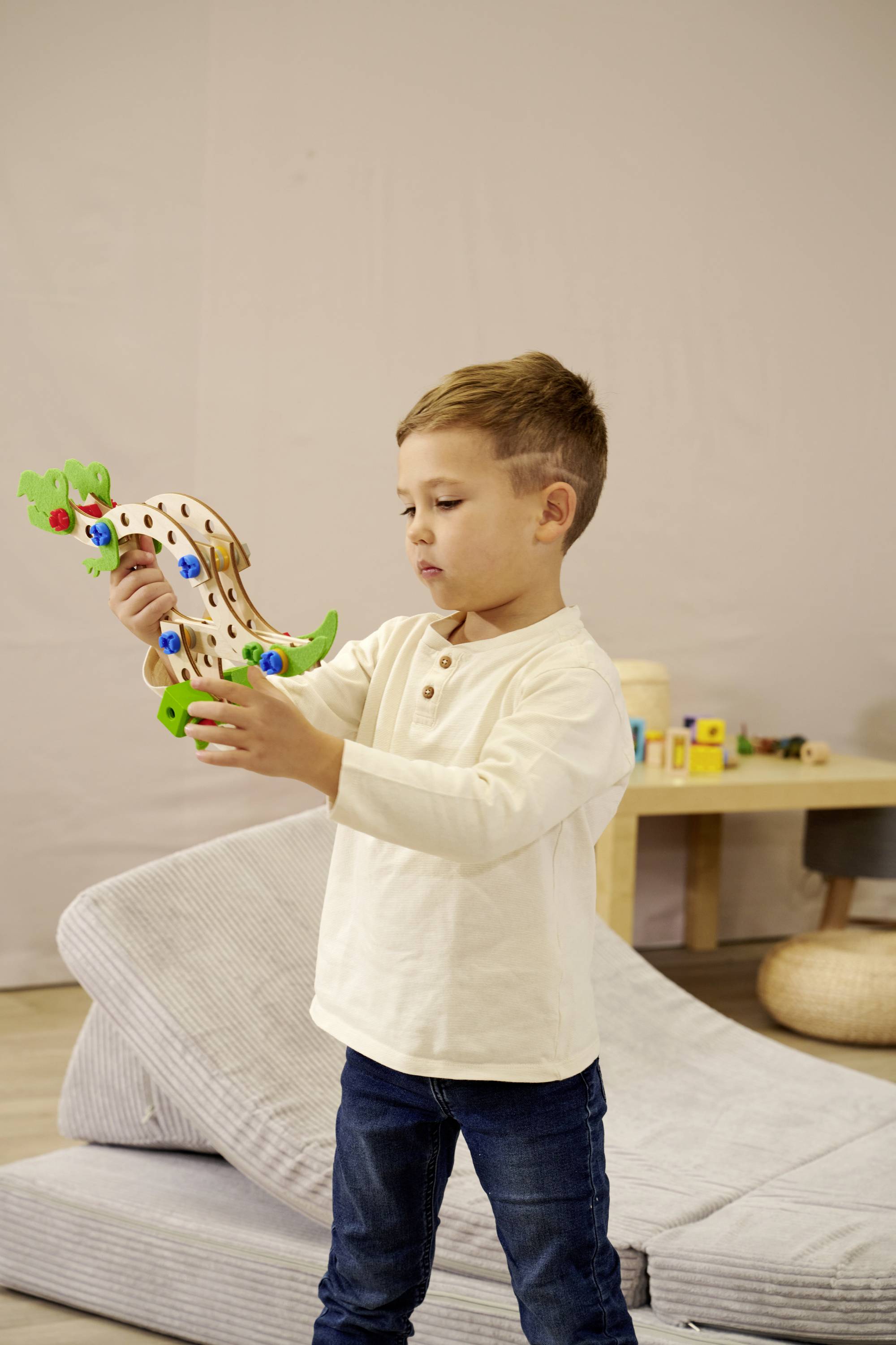 Een kind speelt met een houten speelgoed in een kinderkamer. Het concentreert zich op het evenwichtsspeelgoed in zijn handen.