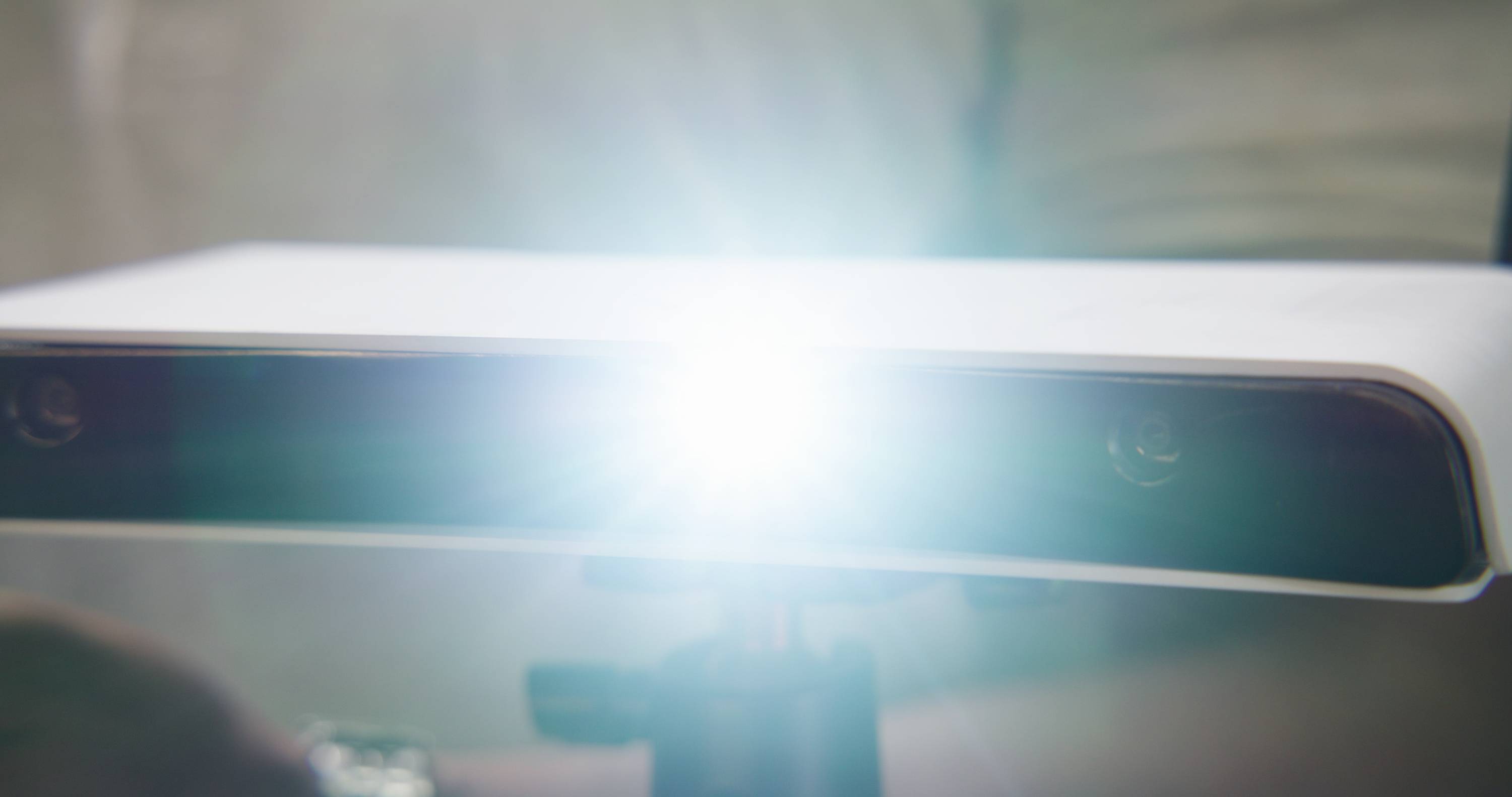 Een camera met een felle lichtflits op de voorgrond, die wordt gebruikt voor opnamen of scans in een mogelijke technische context.