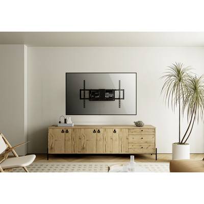 Een modern woonkamer met een houten dressoir en een tv-wandsteun aan de muur. Naast het dressoir staat een plant.