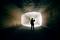 Een persoon staat in een verlichte tunnel en kijkt naar buiten. Silhouet voor een lichte uitgang.