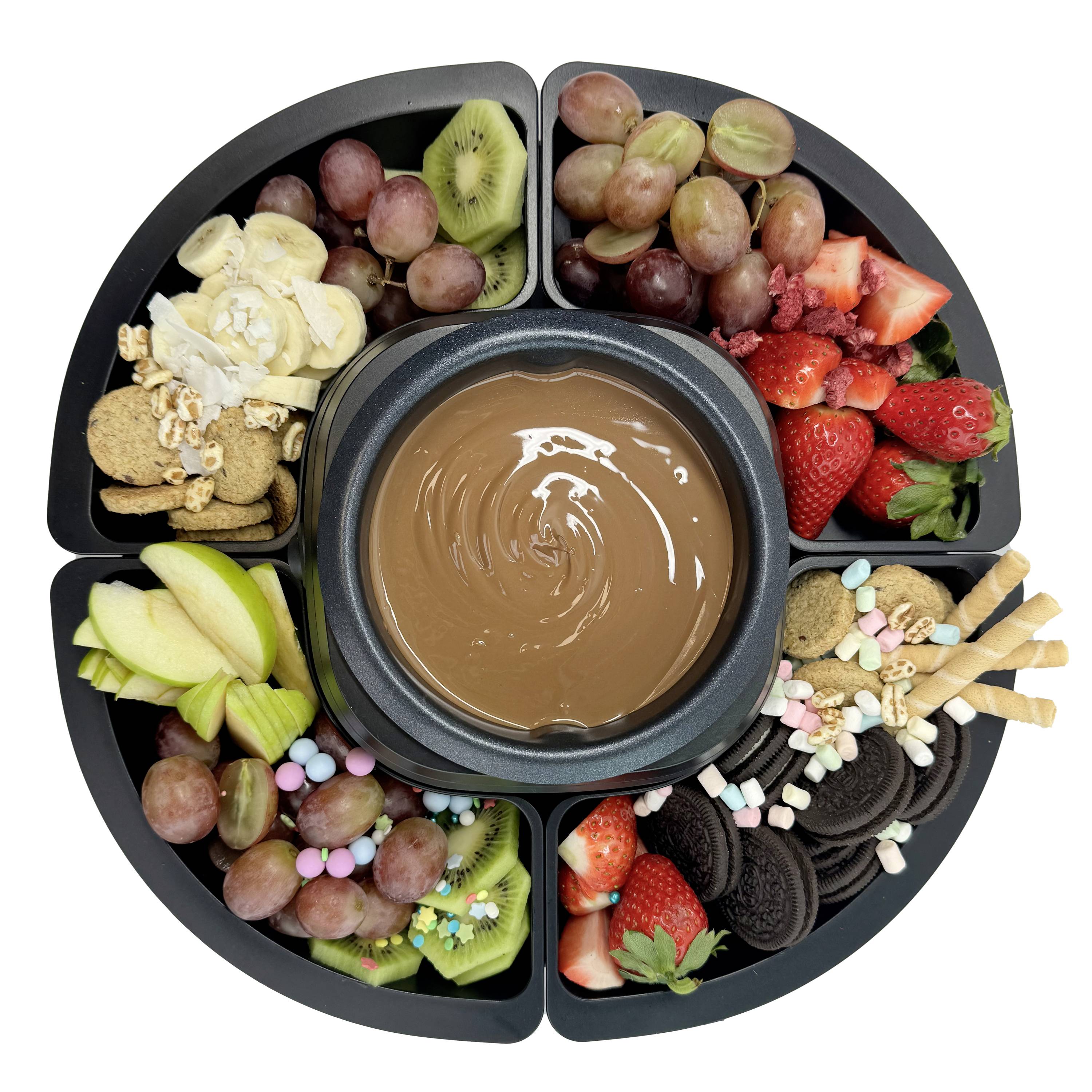 Een rond bord met verschillende vruchten, koekjes en snoepjes rondom een kom met vloeibare chocolade in het midden.