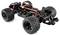 Open chassis van een op afstand bestuurbare auto met grote, robuuste banden en vering. Kabels en motor zichtbaar op het chassis.