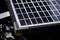 Close-up van een zonnepaneel met donkere panelen op een metalen oppervlak.