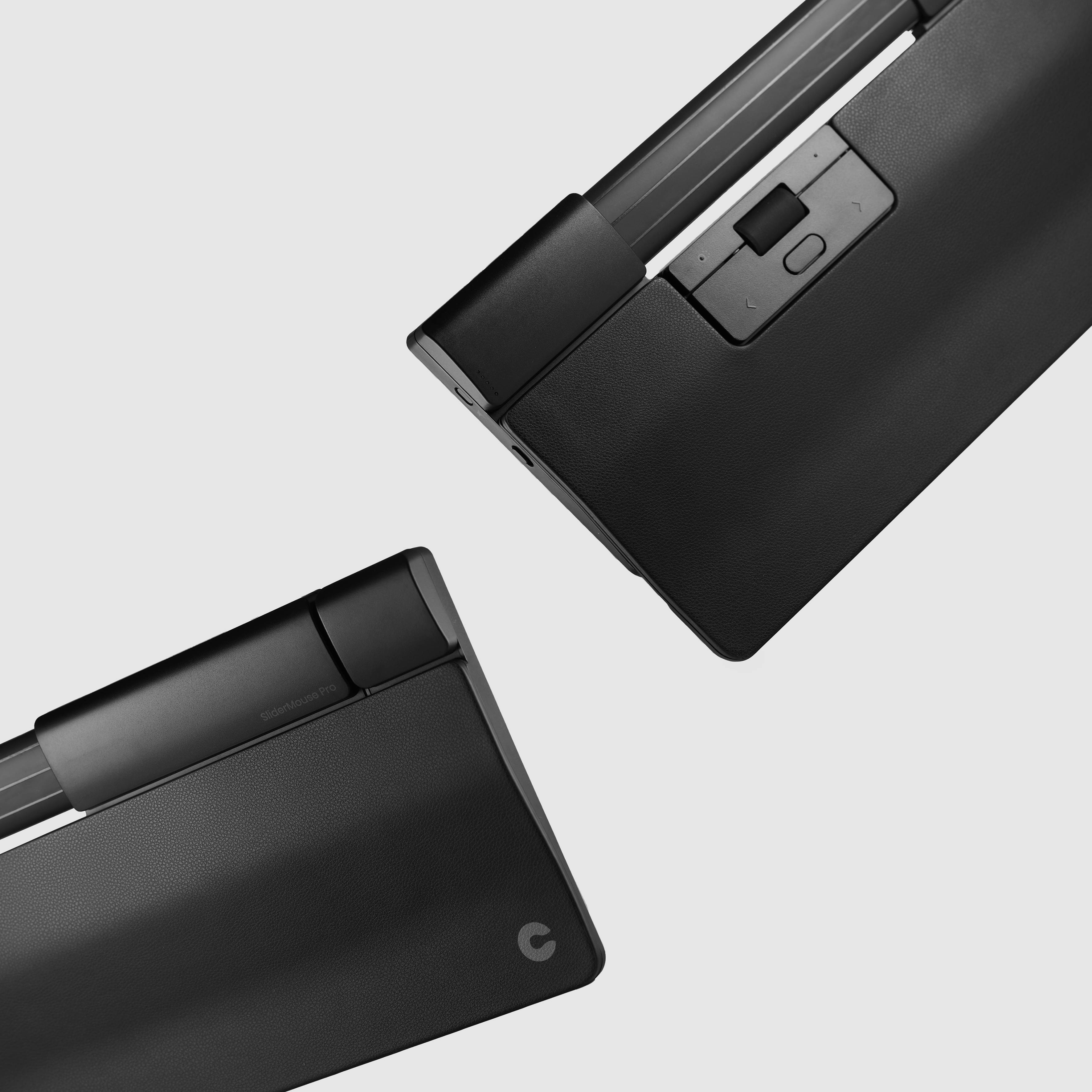 Twee zwarte, moderne apparaten in diagonale opstelling op een grijze achtergrond; tonen een minimalistisch ontwerp met gladde oppervlakken.