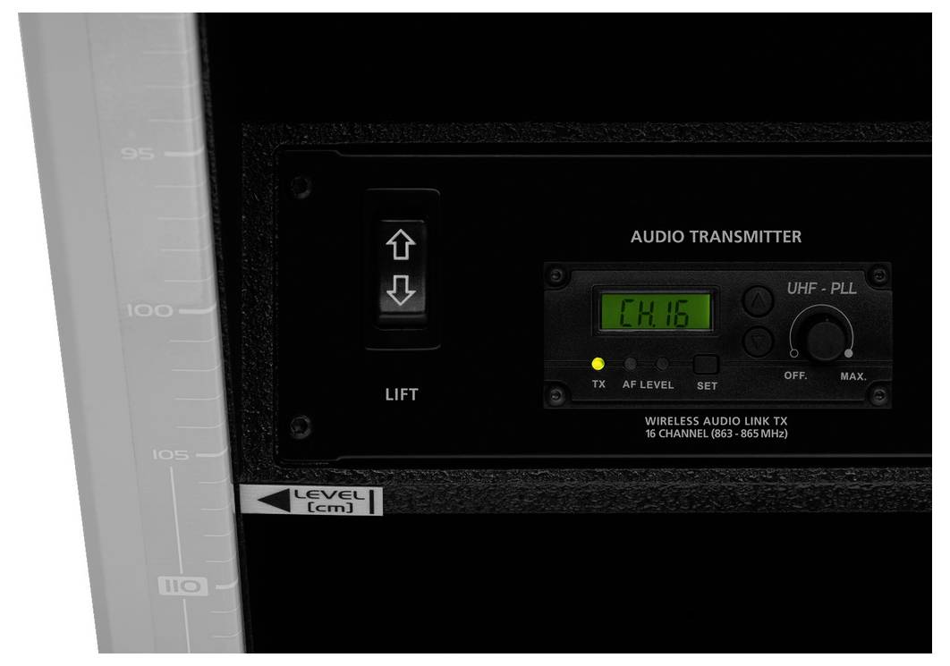 Aanzicht van een audio-zender in een behuizing, onder een liftsymbool met pijlen, naast een display met kanaalindicatie 'CH16'.