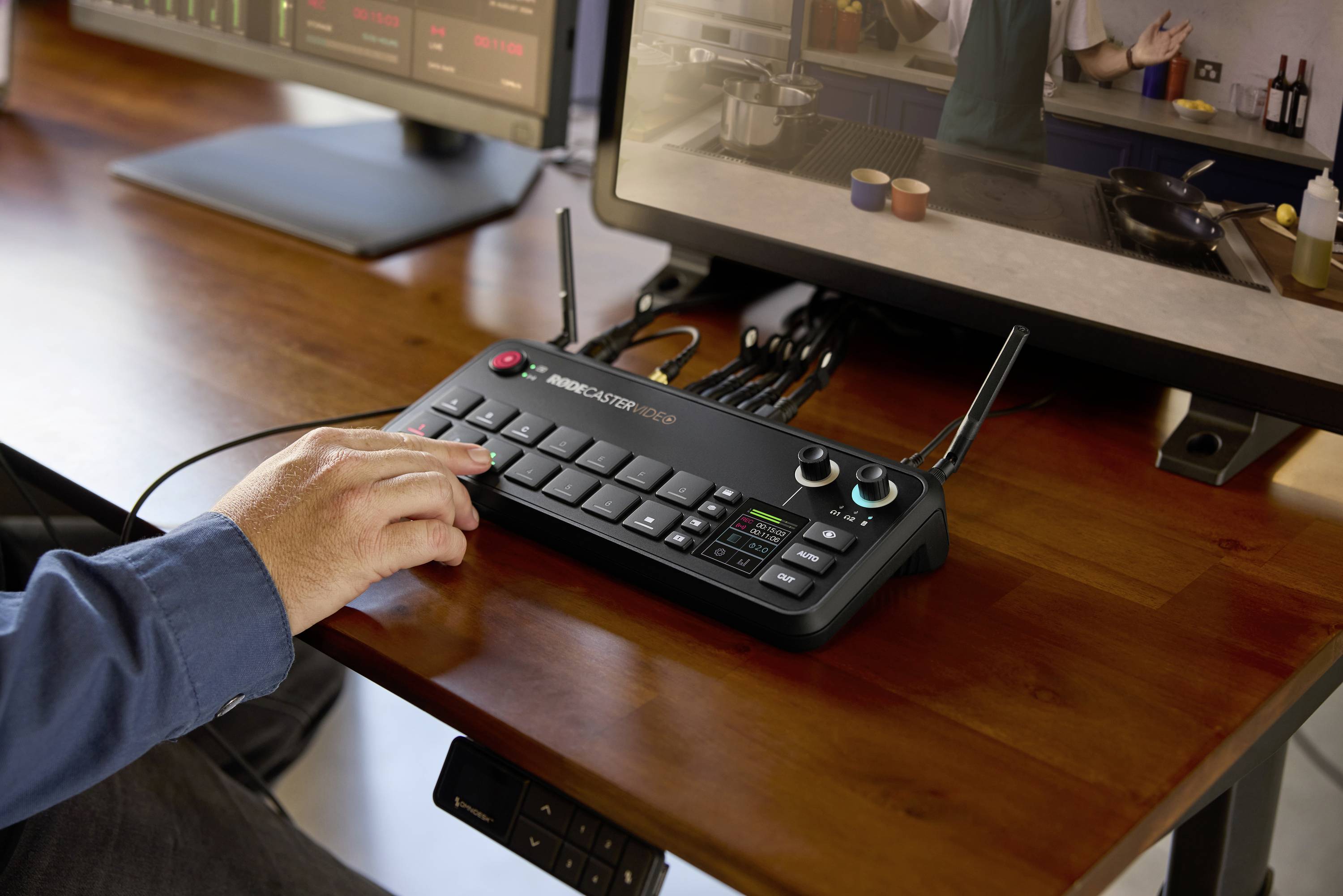Een persoon bedient een videomixconsole voor een scherm waarop een kookprogramma wordt uitgezonden. Naast het bedieningspaneel staan kopjes en specerijen.