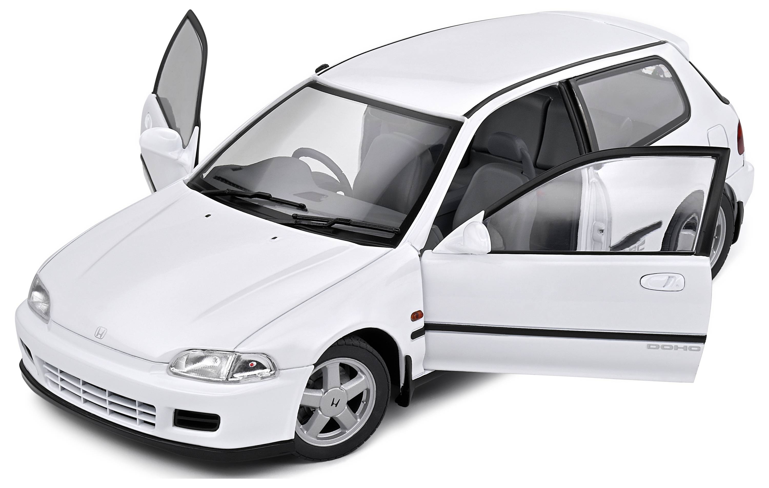 Een witte auto met geopende bestuurders- en passagiersdeur staat schuin voor de camera. Het is een compacte auto met drie deuren.
