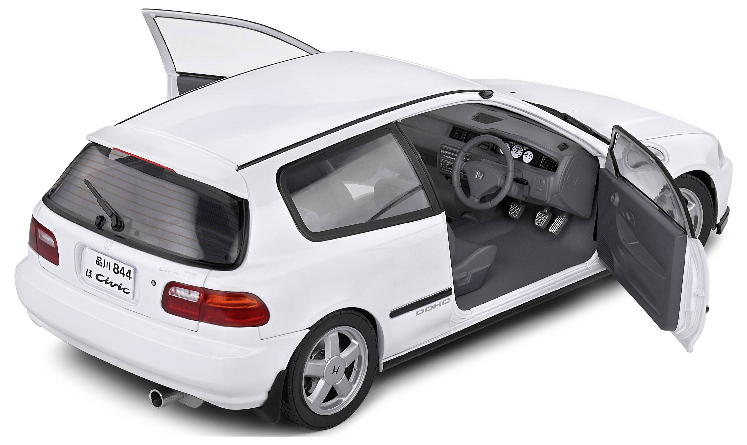 Een witte auto met open deuren, waarbij het interieur en het dashboard zichtbaar zijn. De auto heeft een sportief design.