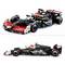 Speelgoedmodel van een racewagen in zwart-wit met rode accenten, gebaseerd op een Formule 1-ontwerp.