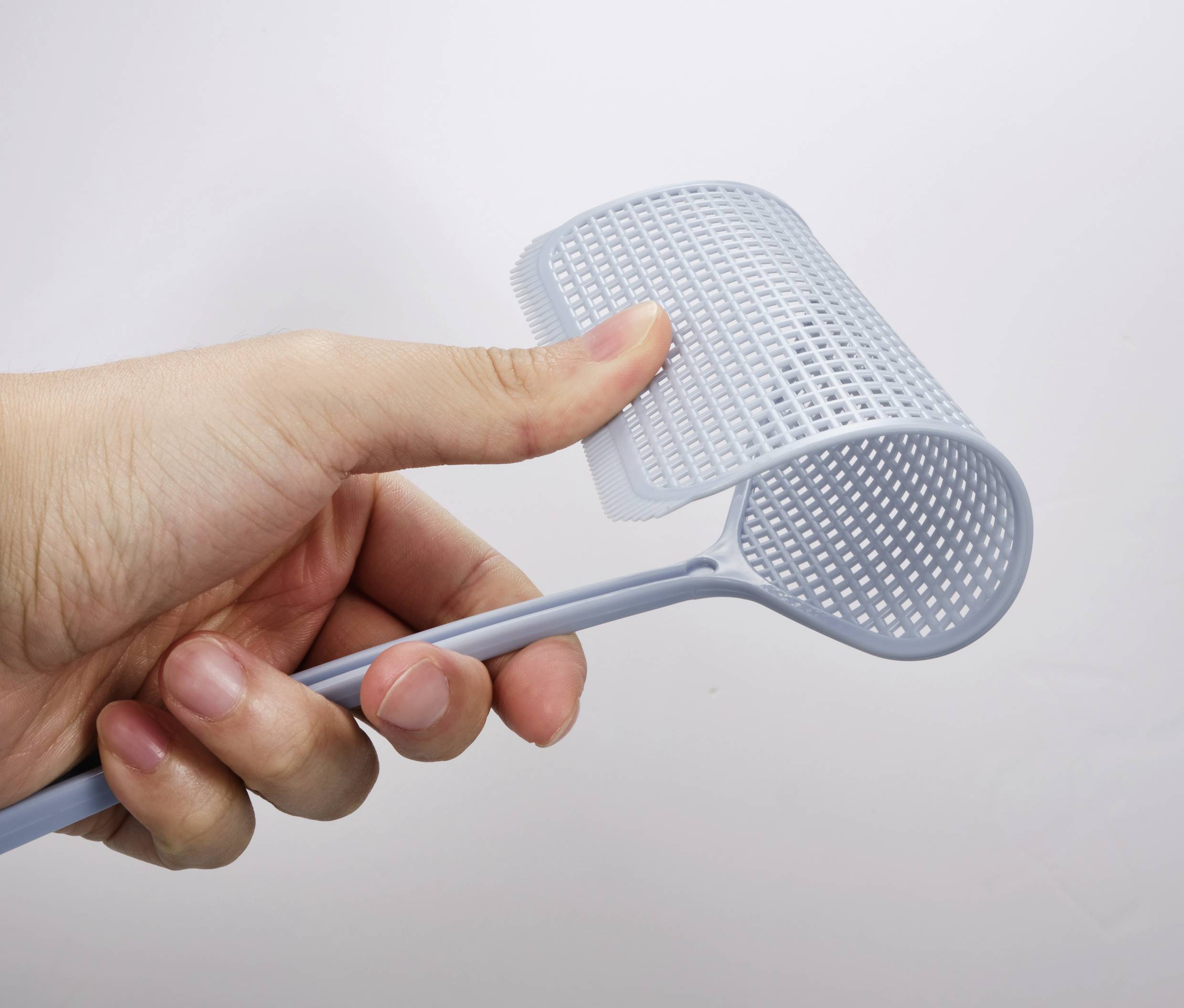 Een hand houdt een flexibele, grijze handgreep met een roosterachtige structuur tegen een witte achtergrond.