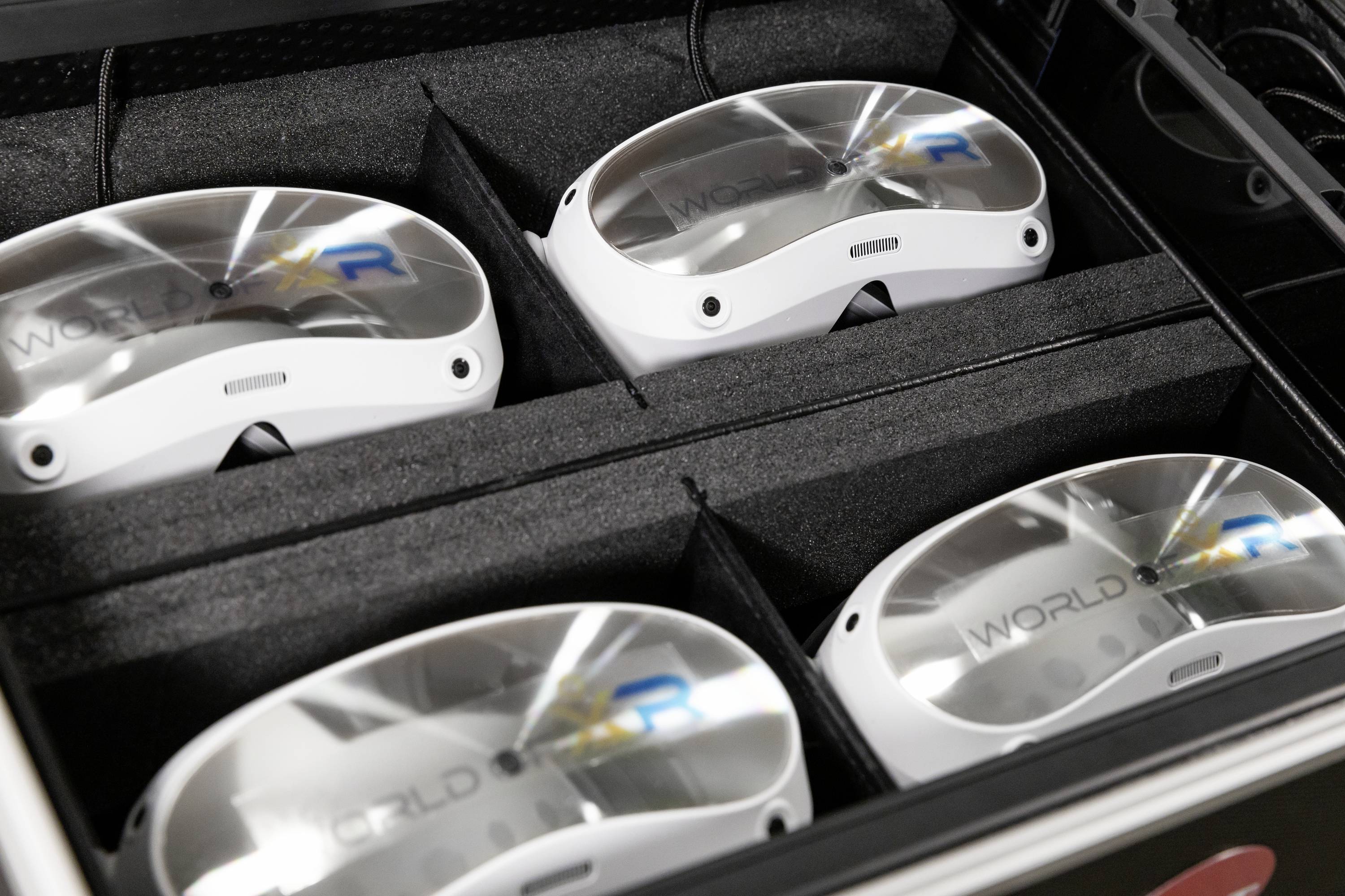 Vier Virtual-Reality-headsets netjes naast elkaar gerangschikt in een zwarte professionele koffer.