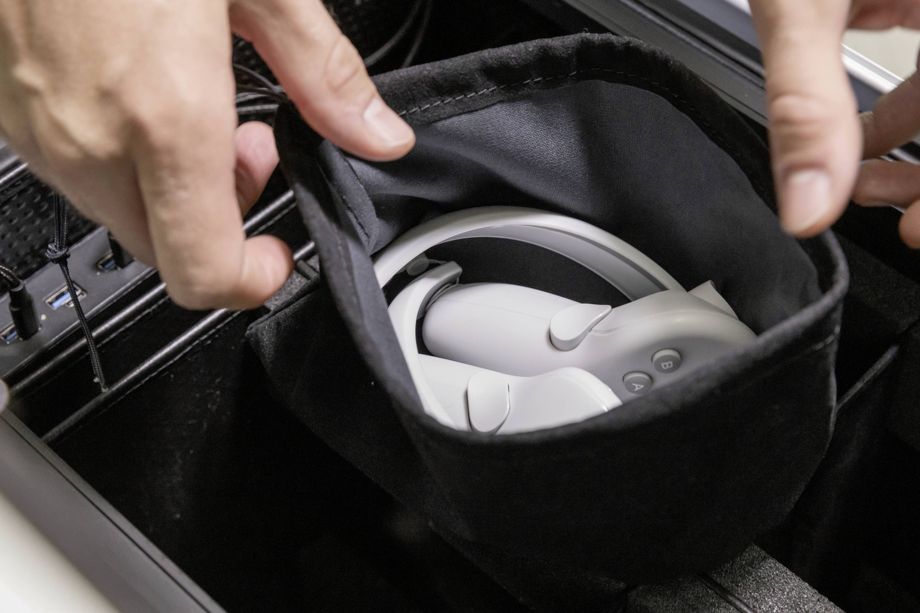 Een persoon legt een virtual-reality-headset in een zwarte tas. Gedetailleerde context of doel is onduidelijk.