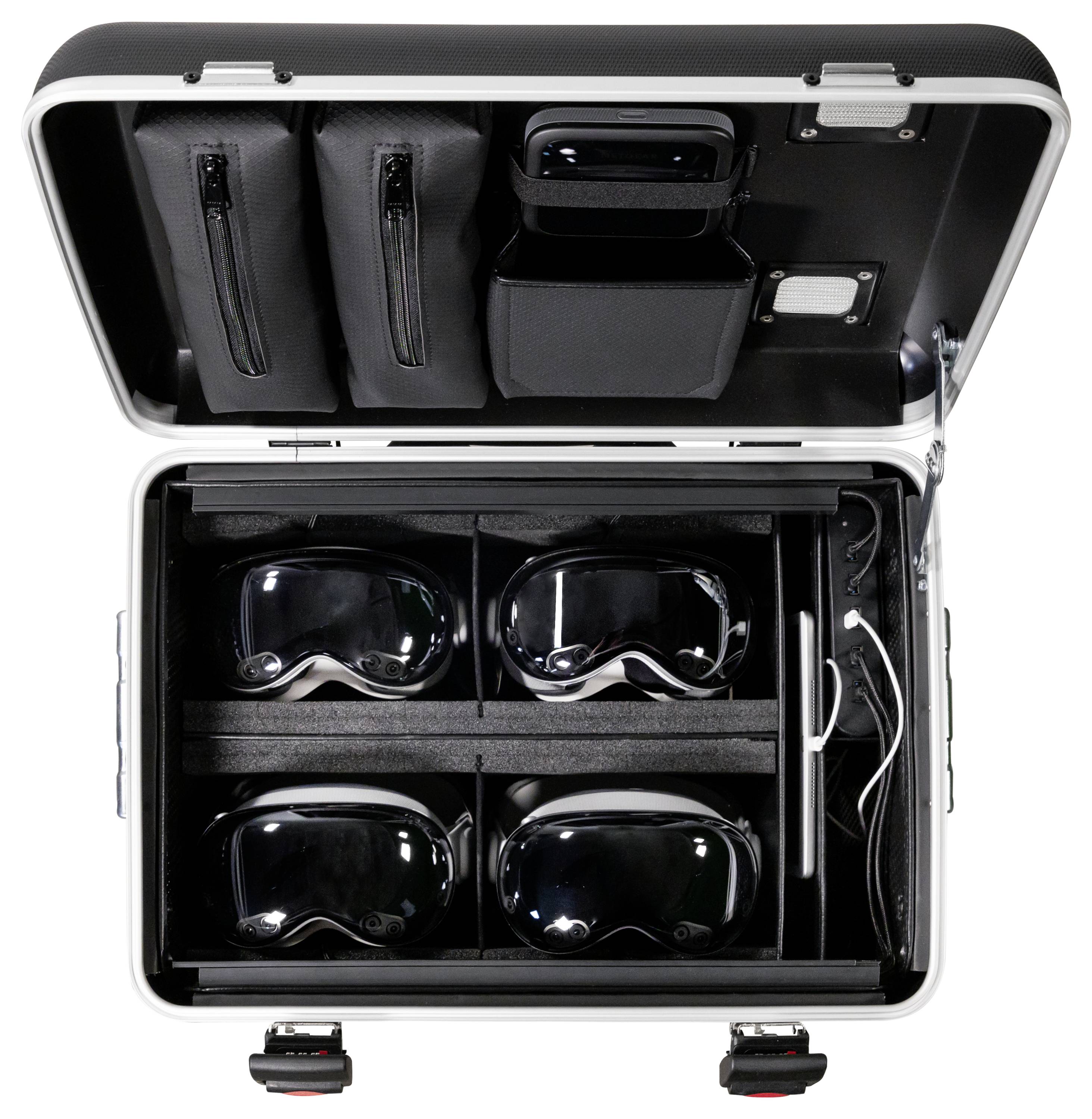 Een open koffer bevat vier VR-headsets in afzonderlijke vakken, evenals laadkabels en toebehoren in bijbehorende tassen.