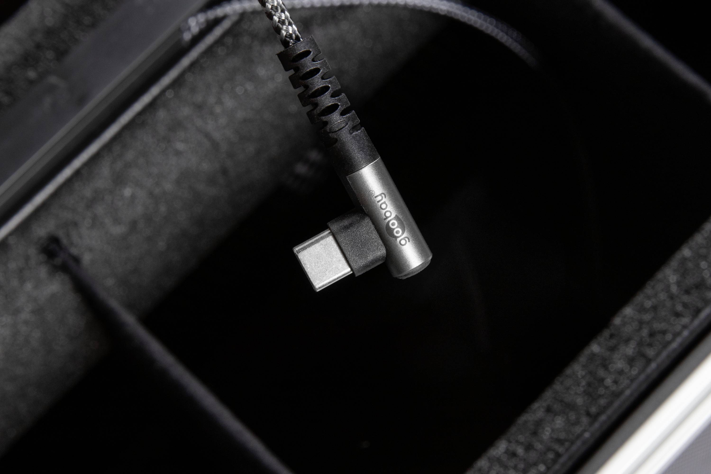 Close-up van een USB-C-kabel met opdruk 'iFi audio', hangend in een apparatenkoffer.