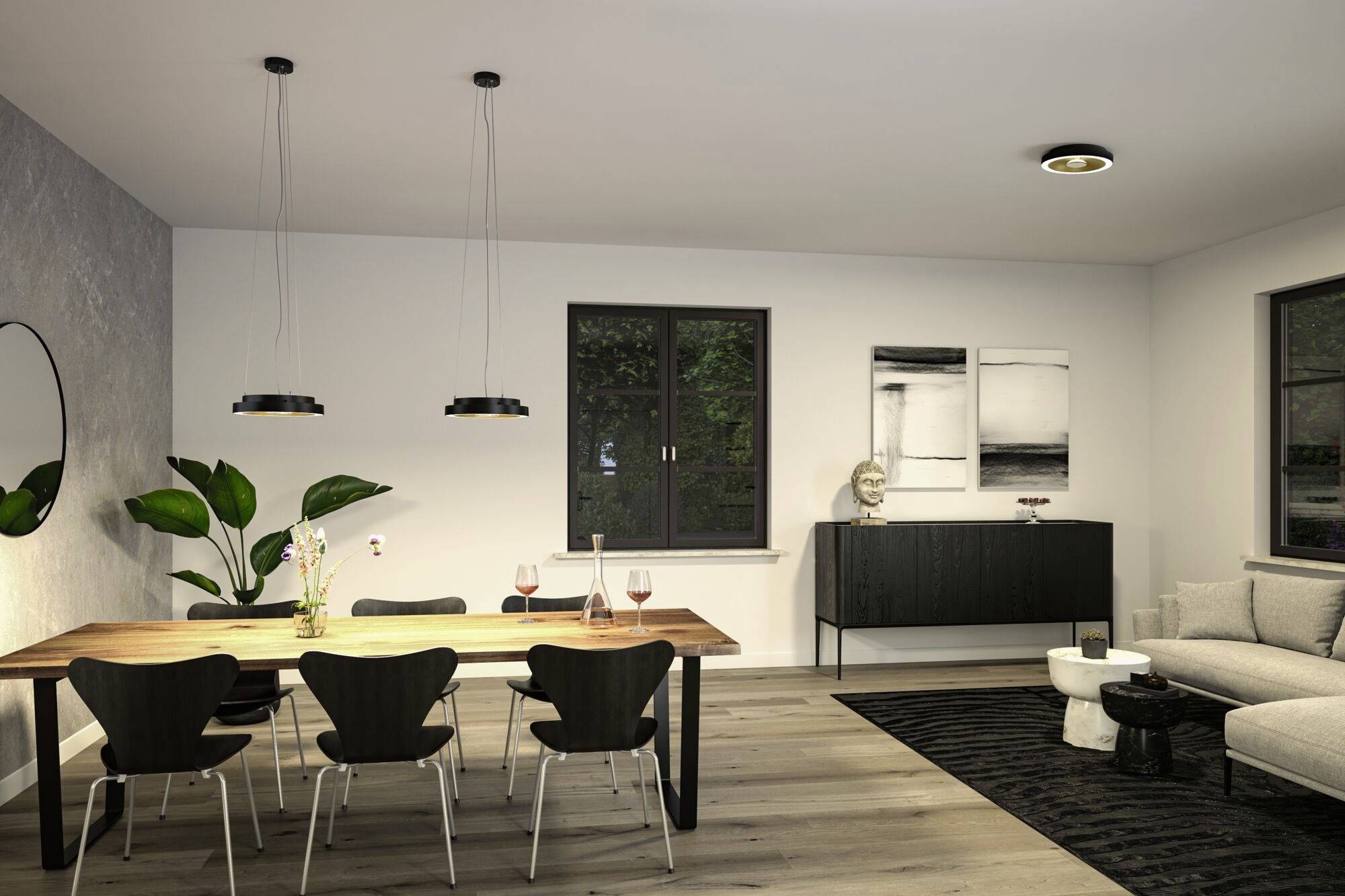 Eetkamer met houten tafel, zes stoelen, twee wijnglazen. Hangende lampen, plant, schilderijen aan de muur, kast en bank op de achtergrond.