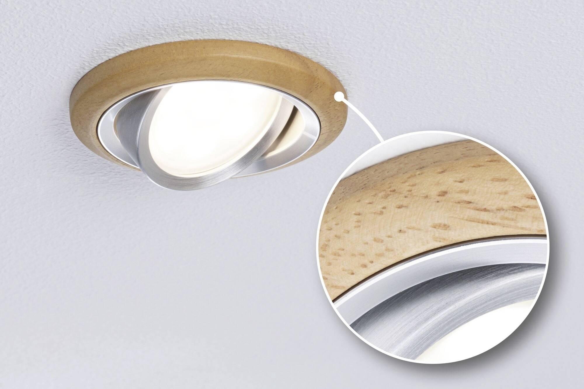 Ronde plafondlamp met houten frame en verchroomde rand, verlicht. Vergroot detail toont close-up van het houten frame.