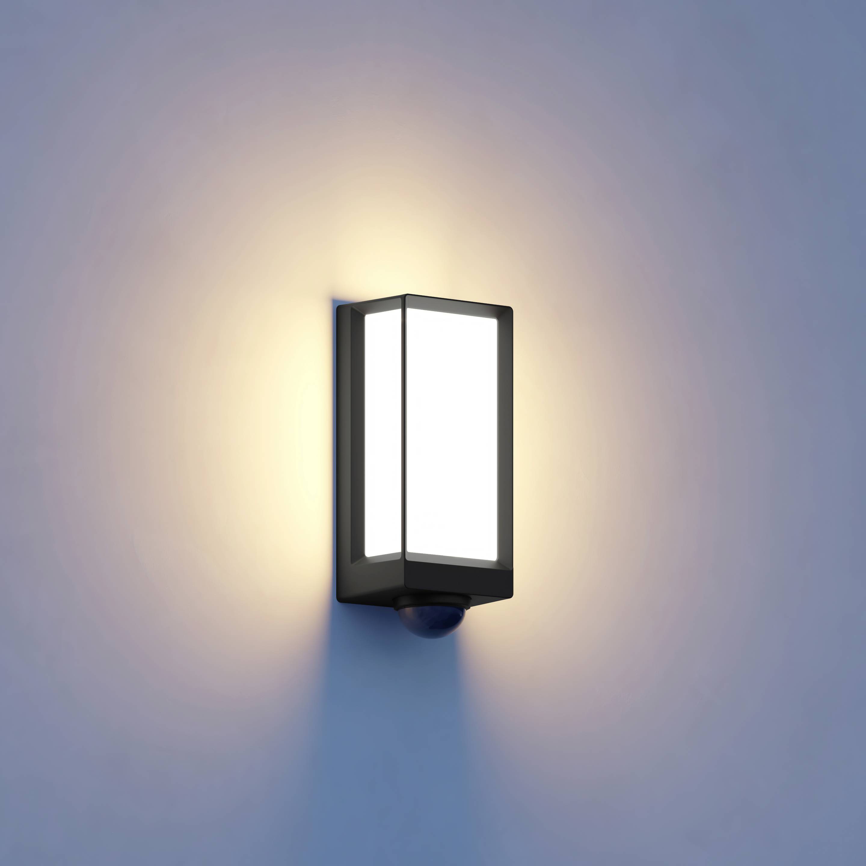 Buitenwandlamp met rechthoekig, modern design straalt warm licht op lichtblauwe muur.
