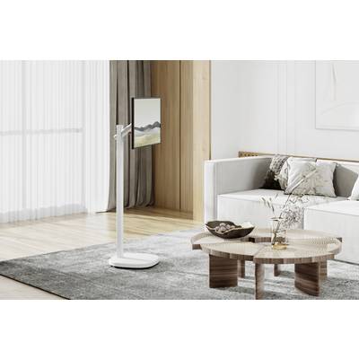 Moderne, minimalistische woonruimte met grijze vloerbedekking, houten salontafel en lichte bank. Plat scherm op staande houder links.