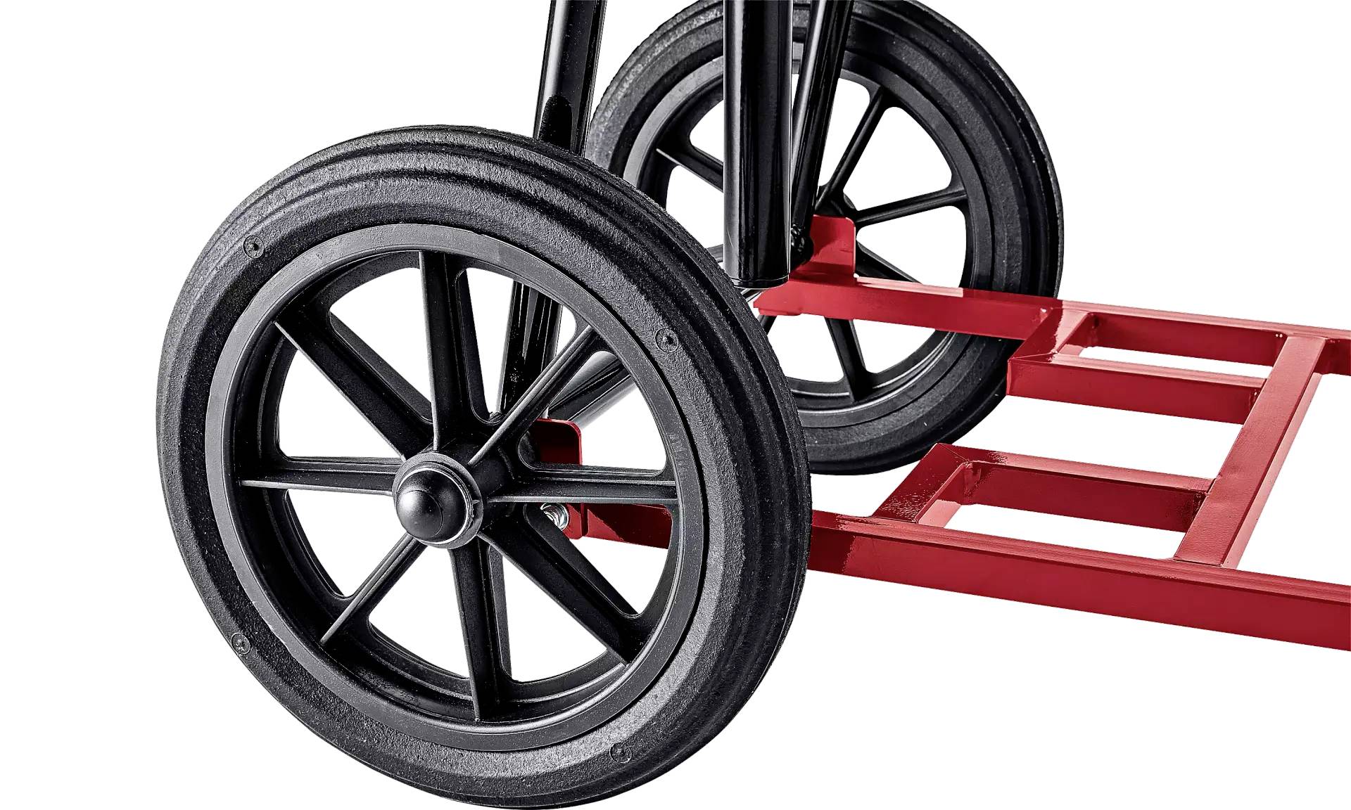Close-up van een transportwagen met grote, zwarte wielen en een rood metalen frame, geschikt voor goederenvervoer.