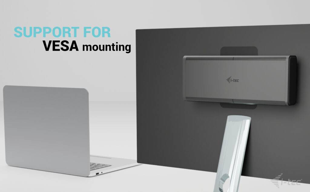 Een kleine computer is bevestigd aan een achterwand met VESA-montagesteun. Links daarvan staat een laptop om de afmeting te illustreren.