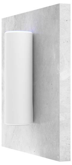 Een witte, cilindrische wandlamp aan een grijze muur, straalt een diffuus licht naar boven en beneden uit.