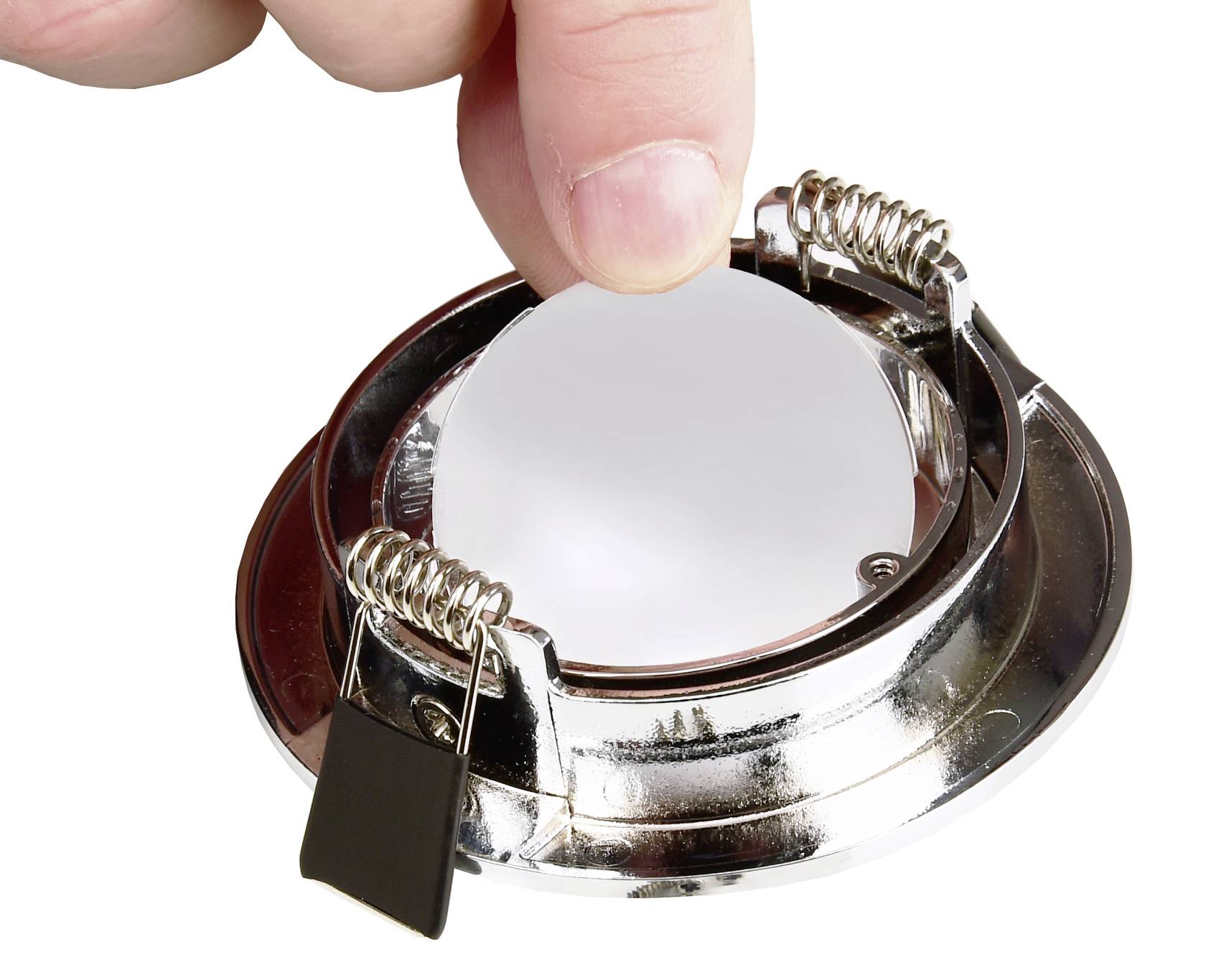 Een hand plaatst een ronde spiegel in een metalen frame met twee bevestigingsklemmen.