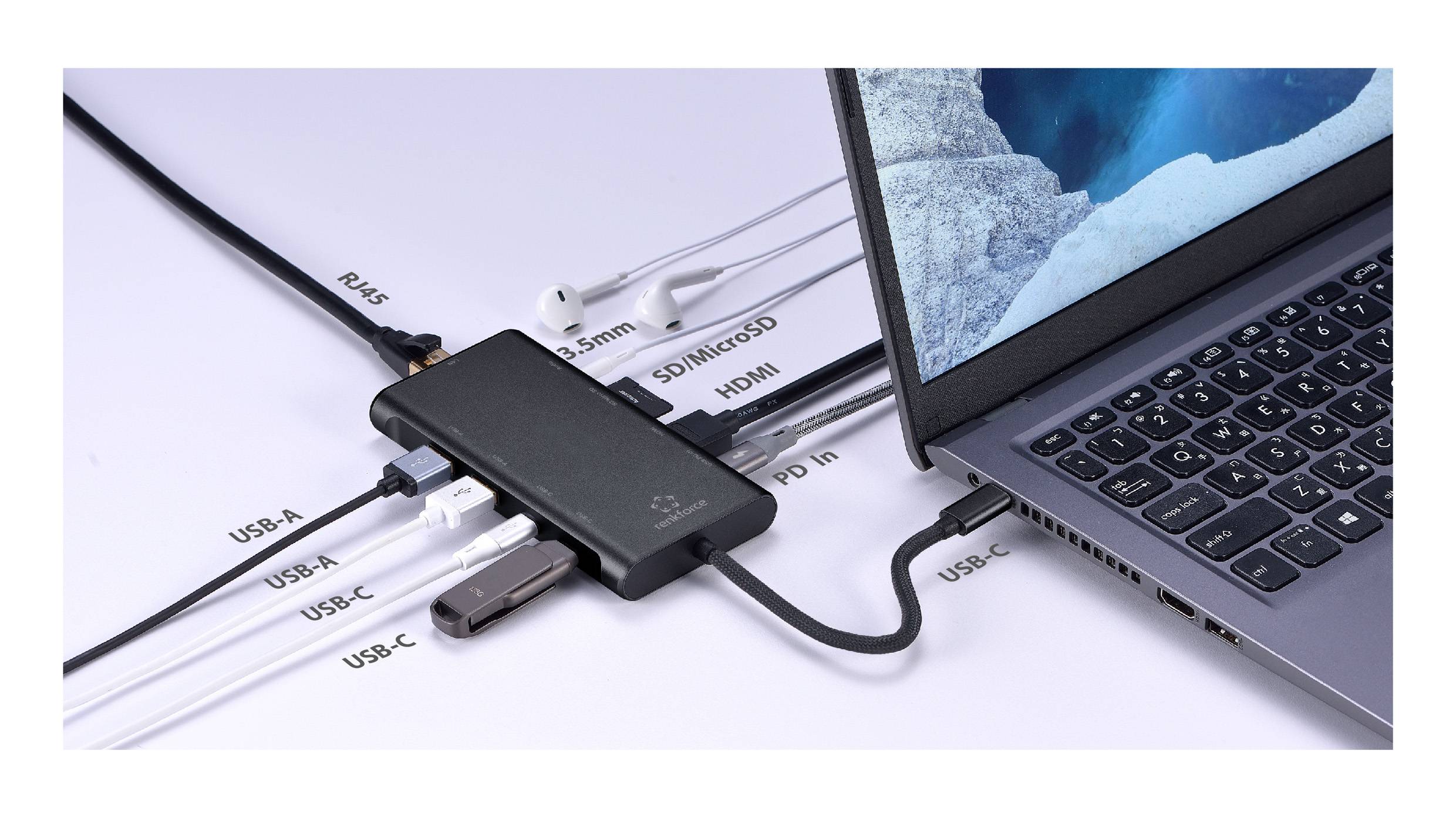 Een laptop aangesloten via een USB-C hub met meerdere poorten: RJ-45, USB-A, USB-C, HDMI, microSD, 3,5mm audio. Nabij zijn de koptelefoons aangesloten.