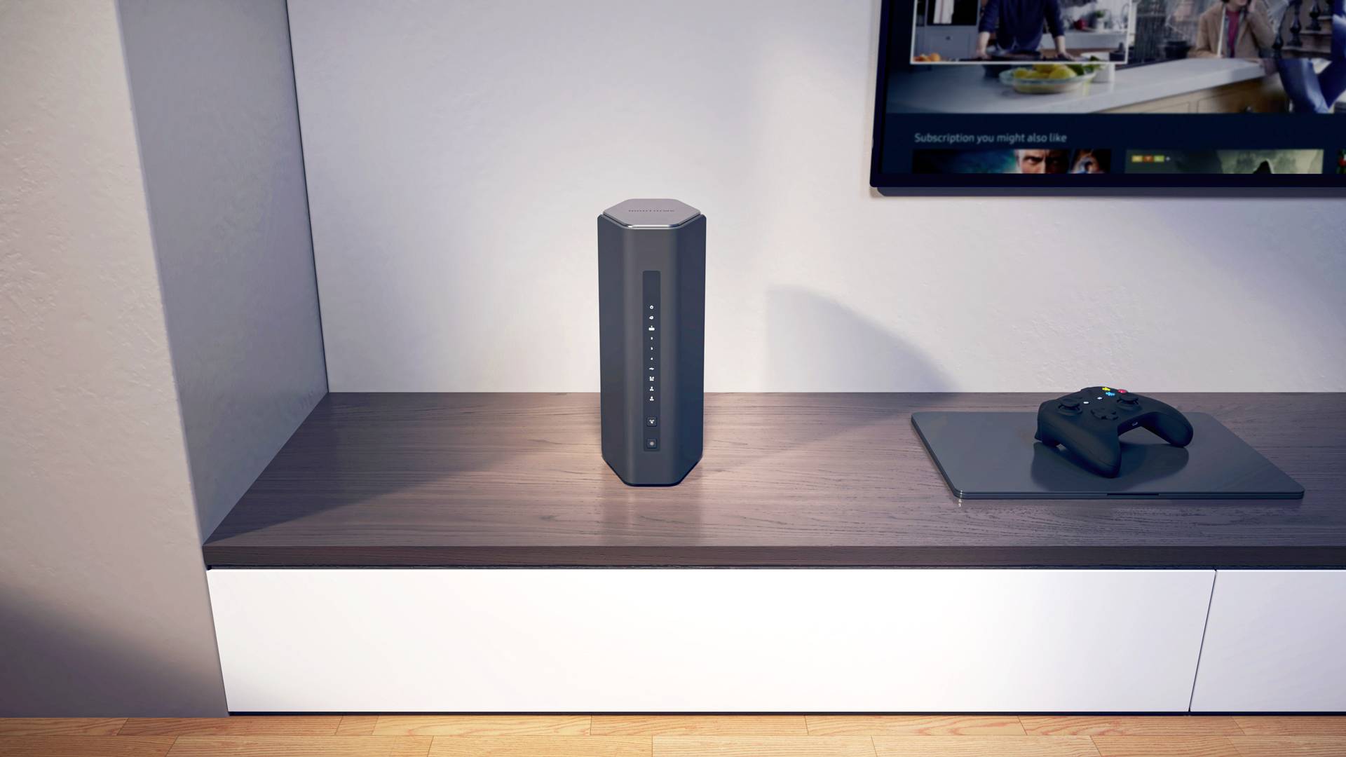 Een grijze, zeshoekige luidspreker staat op een plank naast een gesloten laptop en een controller. Op de achtergrond een televisie.