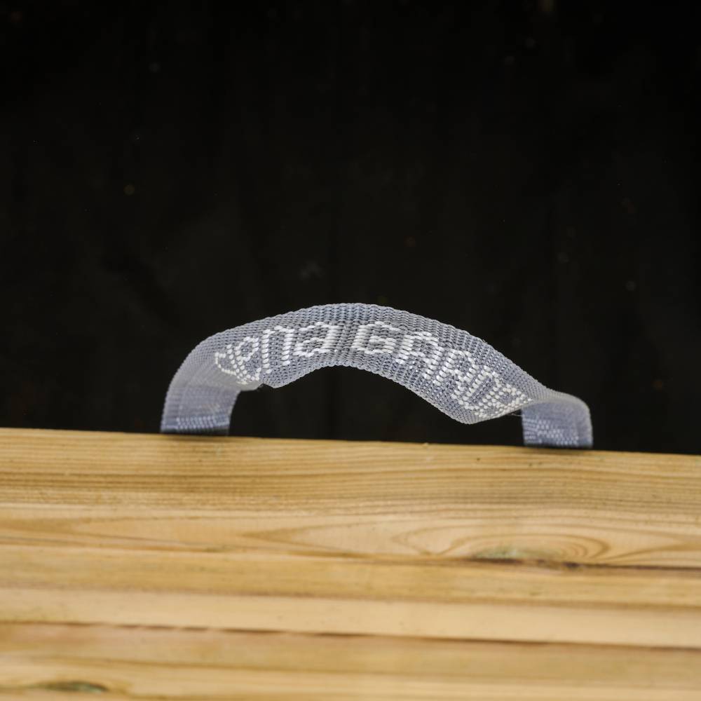 Een klein plastic egel zit op een houten ondergrond voor een zwarte achtergrond. Het patroon op de egel lijkt een gezicht te vormen.