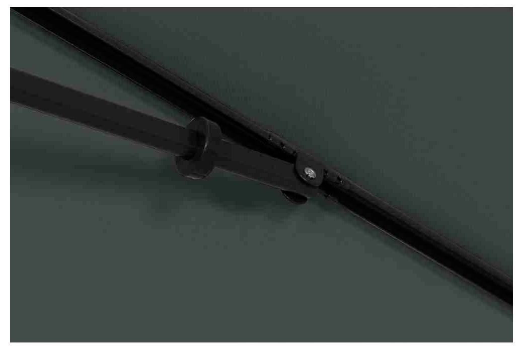 Close-upfoto van een deel van een zwart mechanisme of scharnier, bevestigd aan een metalen of gestructureerde oppervlakte.