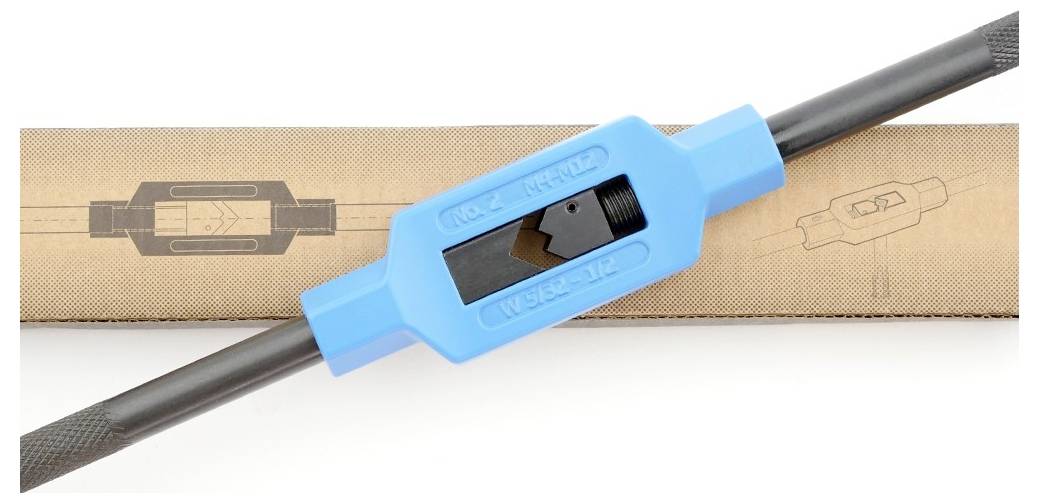 Een blauw gereedschap voor schroefdraadsnijden ligt diagonaal op een bruine doos met een getekende gebruiksaanwijzing van het gereedschap.