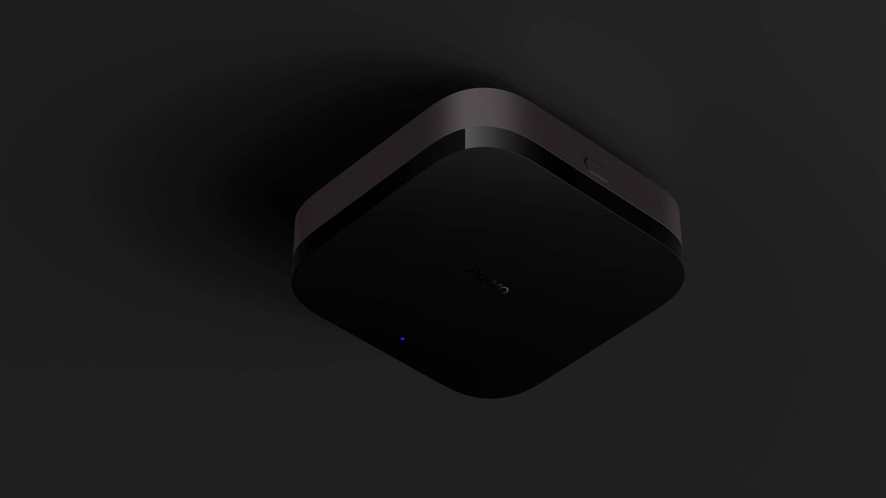 Zwarte vierkante router aan donker plafond gemonteerd, licht blauw op.