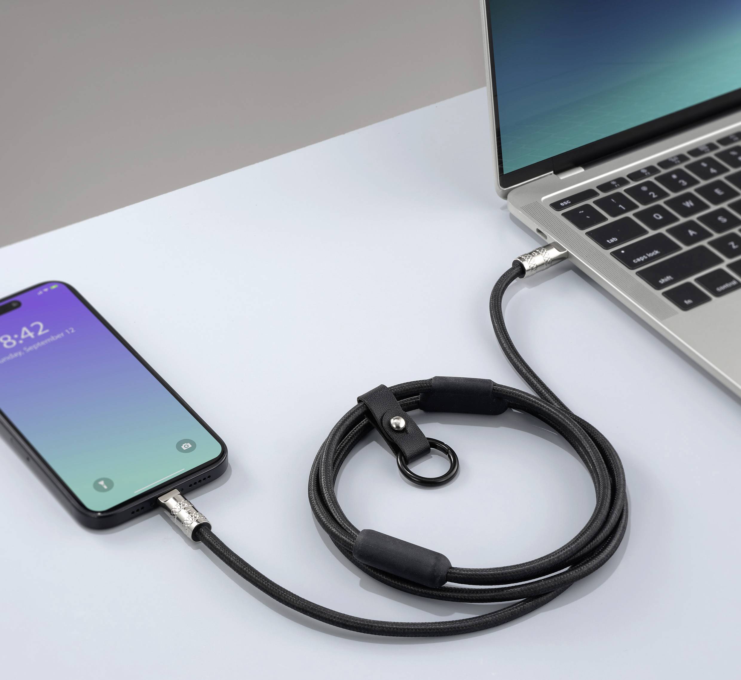 Smartphone verbonden met laptop via een USB-kabel. De telefoon toont een vergrendelscherm.