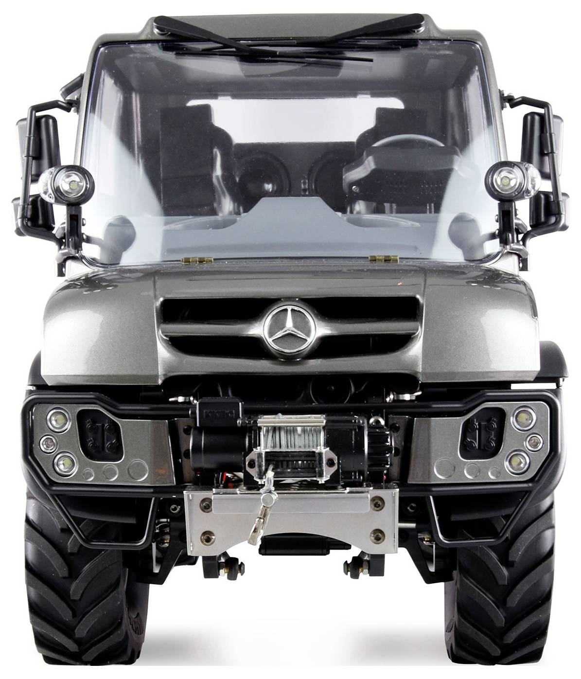 Een zilveren Mercedes Unimog vrachtwagen met robuust design en opvallend embleem, frontaal gefotografeerd op witte achtergrond.