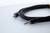 Een zwarte audiokabel met twee 3,5-mm-jackstekkers op een lichte ondergrond.