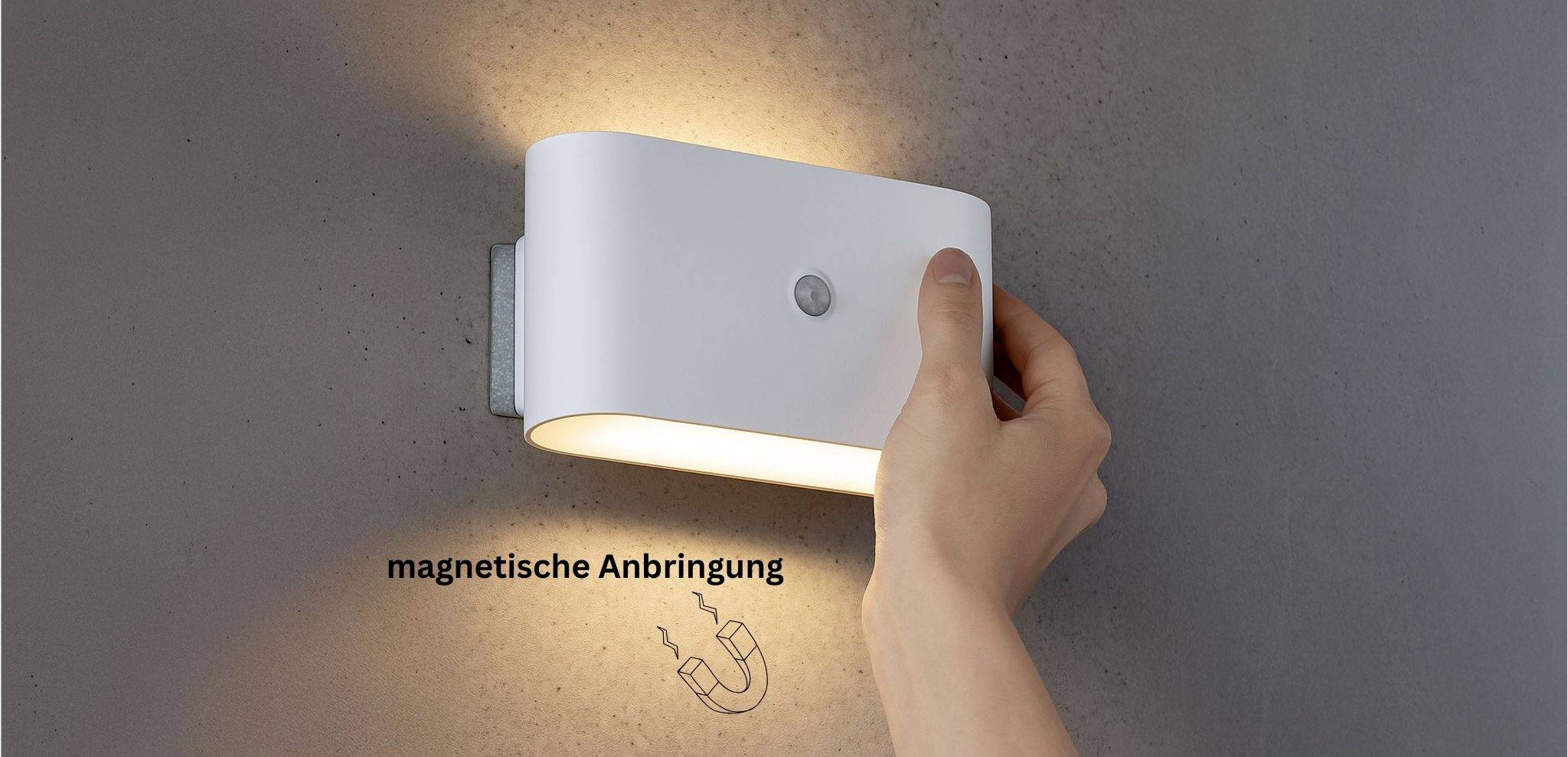 Een hand plaatst een wit, ovaal-vormige wandlamp op een magnetische bevestiging, waarbij de eenvoudige installatie wordt gedemonstreerd. Tekst in het Duits luidt 'magnetische Anbringung'.