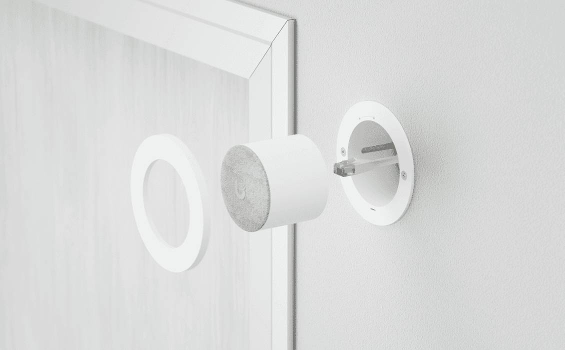 Een magnetisch montagesysteem toont drie onderdelen: een ronde wandbevestiging, een cilindrische magneet en een frame.