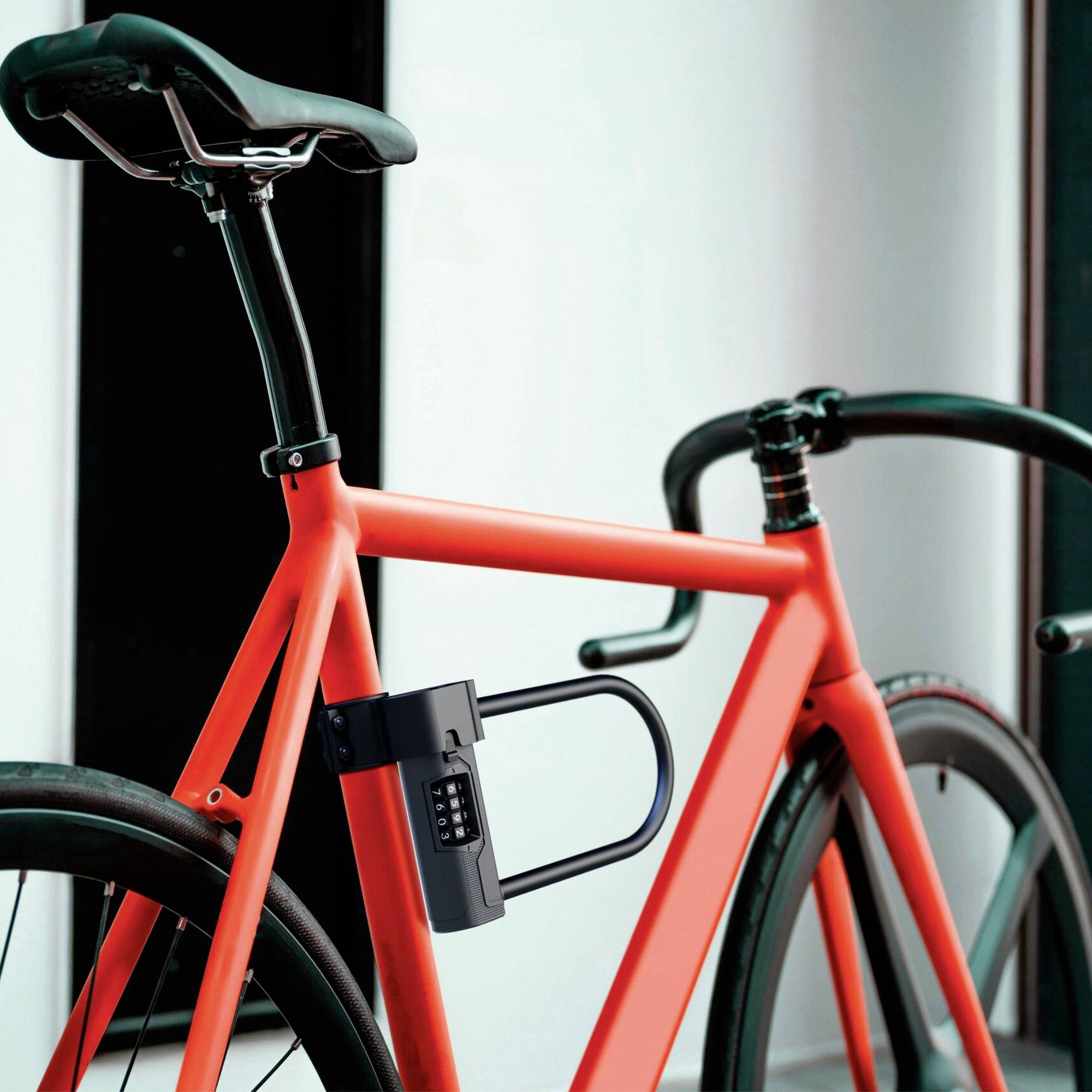 Rode fiets met zwart cijferslot aan het frame in een moderne ruimte.