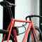 Rode fiets met zwart cijferslot aan het frame in een moderne ruimte.
