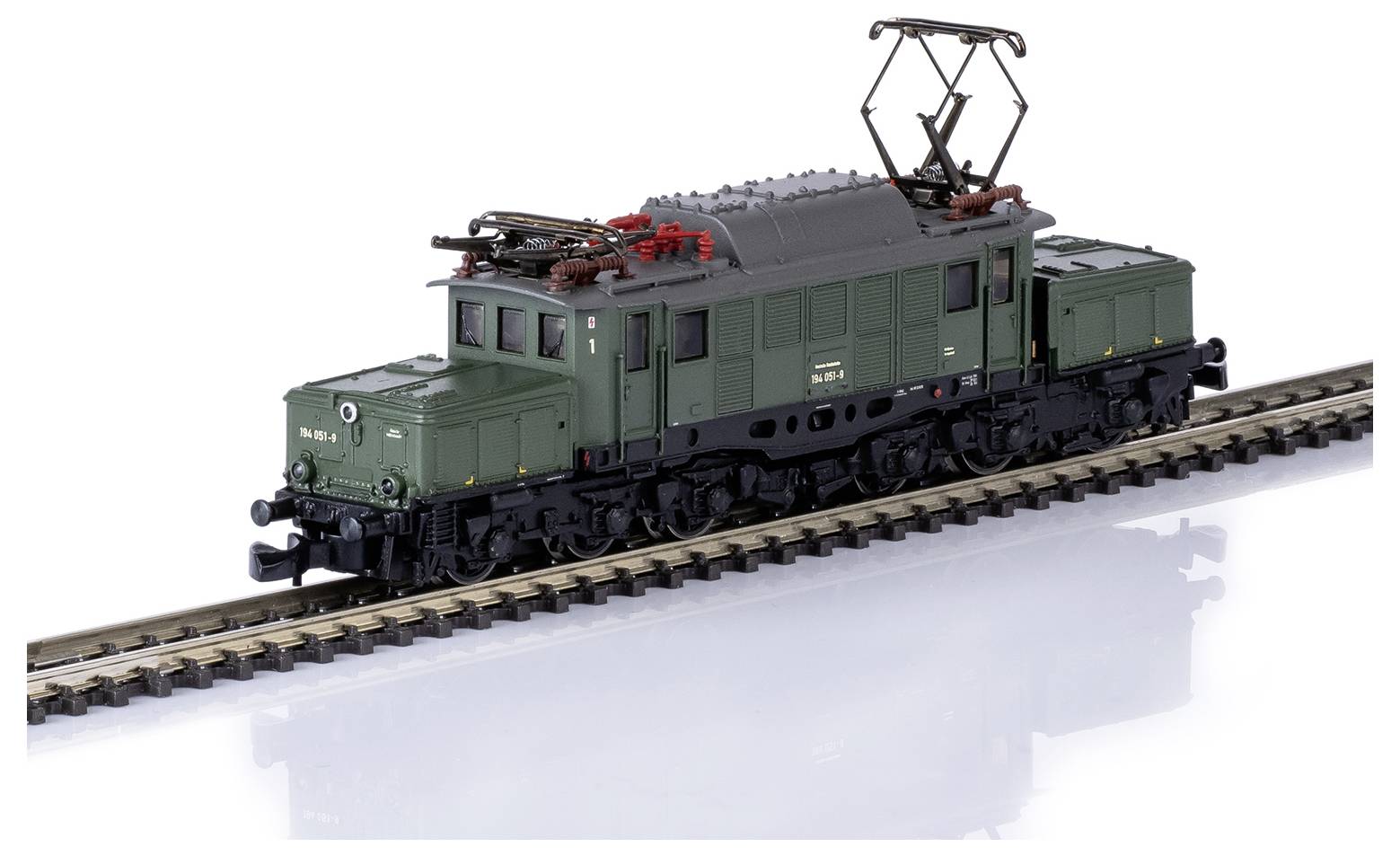 Een modeltreinstel op een spoor, bestaande uit een groene locomotief met stroomafnemers.