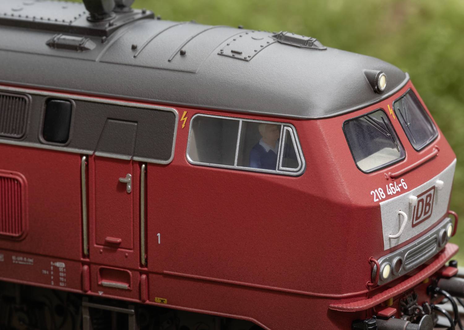 Een rode locomotief van Deutsche Bahn, zijaanzicht van de cabine, met duidelijke details van de ramen en structuren.