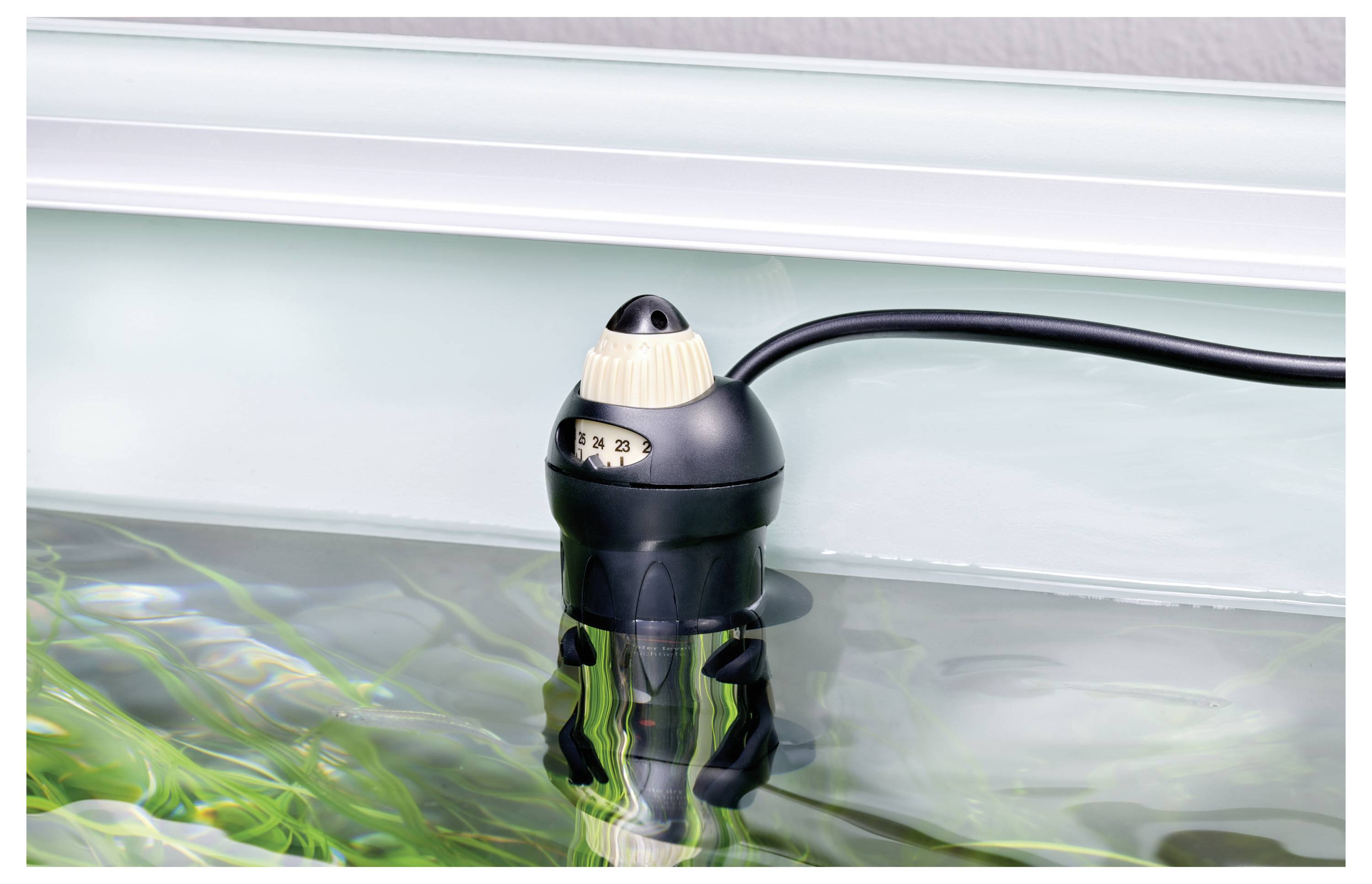 Een zwarte aquariumverwarming die gedeeltelijk ondergedompeld is in water, met een temperatuurinstelknop bovenop en een stroomkabel die ervan afhangt.