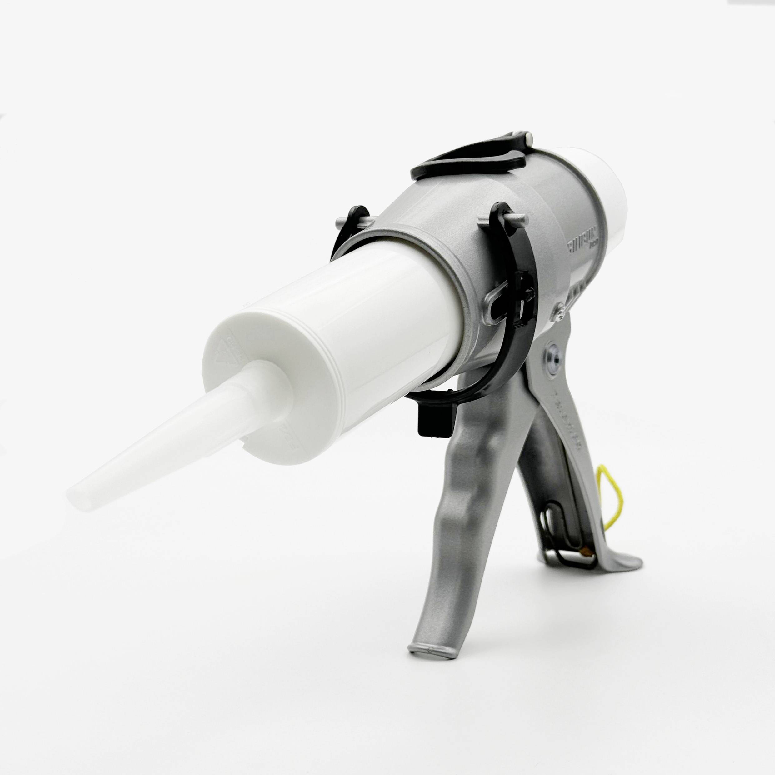 Een grijze patroonpistool met een witte patroon, liggend op een neutrale achtergrond. Het is gebruiksklaar.