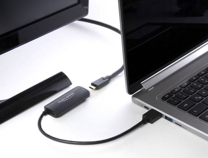 Een laptop is via een kabel verbonden met een adapter, die vervolgens is aangesloten op een televisie om inhoud over te dragen.