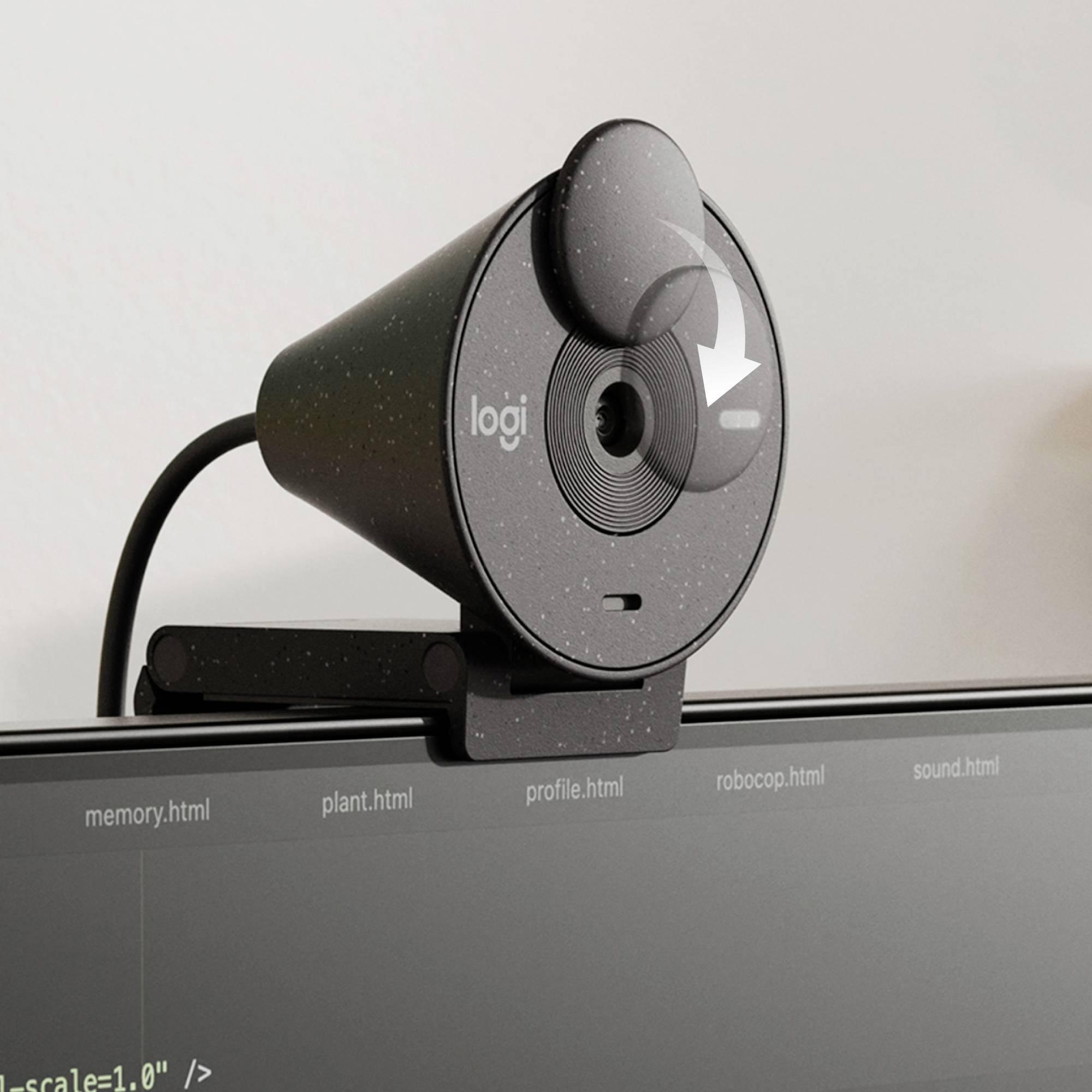 Een zwarte webcam zit op een computermonitor. Daaronder is code zichtbaar op een scherm.