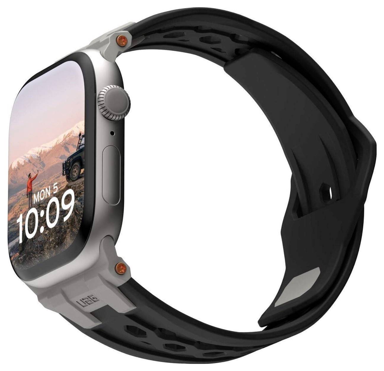 Zilveren smartwatch met zwarte polsband, toont de tijd '10:09'. Achtergrondafbeelding vertoont een berglandschap met een terreinwagen.